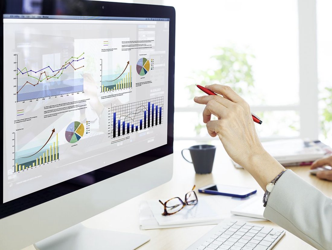 Persona revisando gráficos de resultados en un monitor
